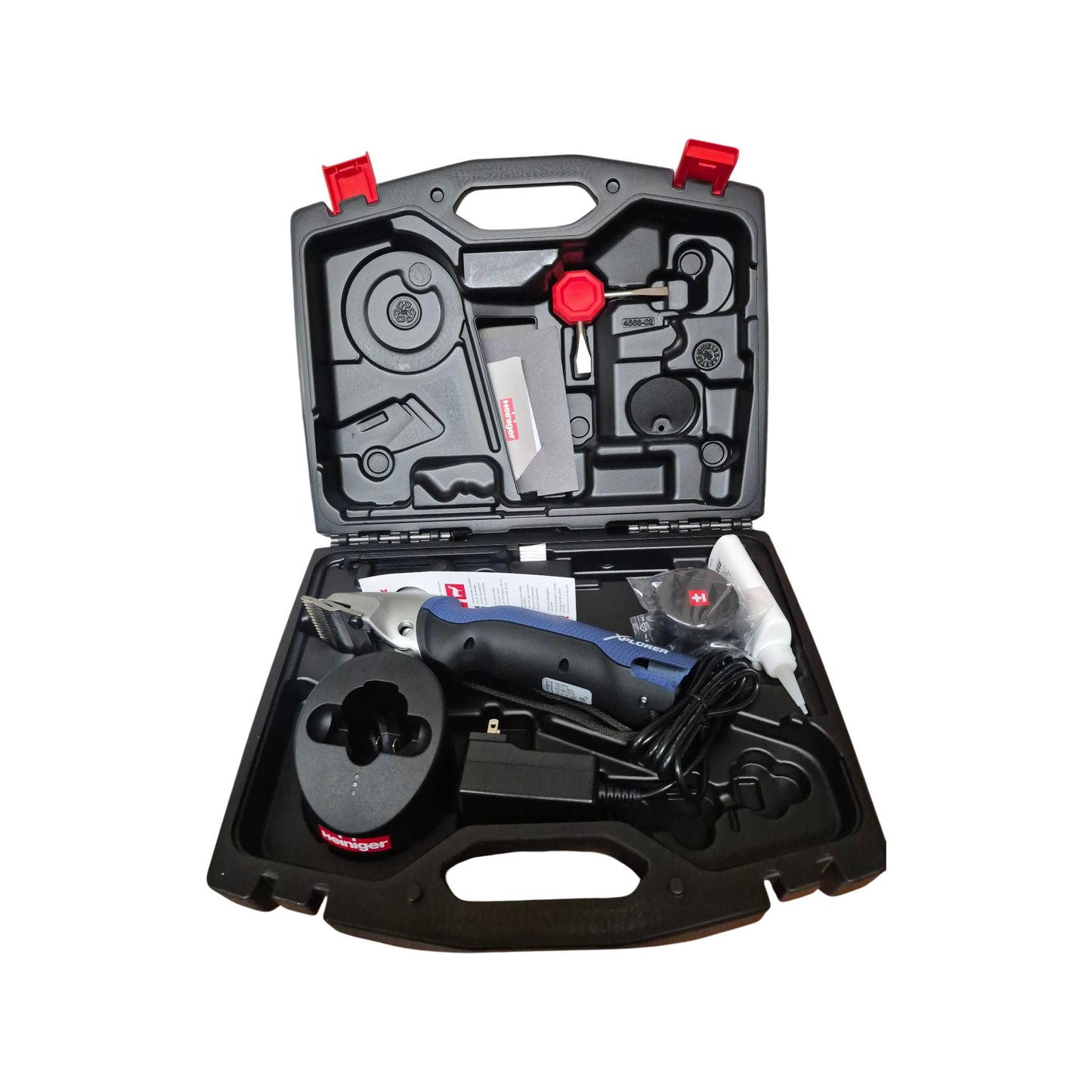 An open Heiniger Xplorer cordless clipper kit with the large animal clipper, battery, charger, blade set and accessories in the carrying case