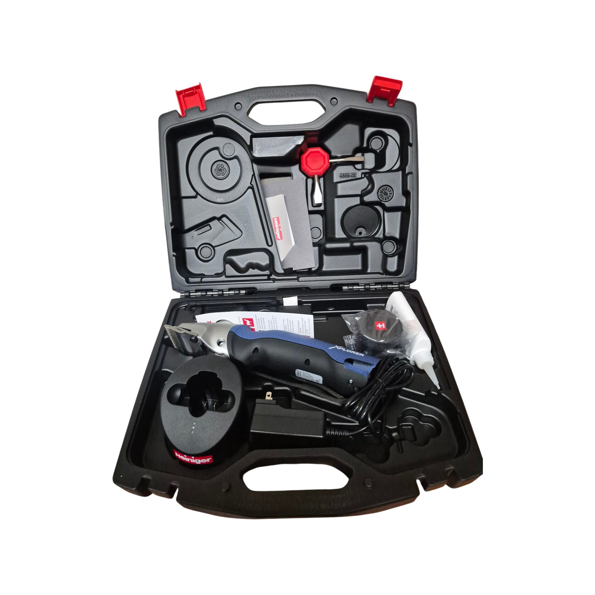 An open Heiniger Xplorer cordless clipper kit with the large animal clipper, battery, charger, blade set and accessories in the carrying case
